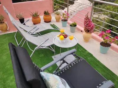 a patio with a table and chairs and potted plants at Rocky Mountain Villa in Ramní