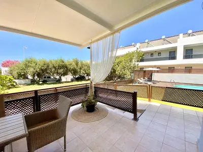 a balcony with a table and chairs and a pool at PRIMAVERA in Kalamaki Chanion