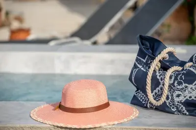 a pink straw hat sitting next to a purse at Pink Sand Villas in Agios Padeleimon