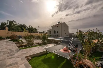 a view of a backyard with a table and grass at Pink Sand Villas in Agios Padeleimon