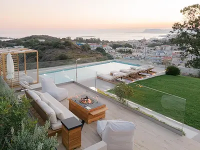 a patio with white furniture and a swimming pool at Centro Golden View Villa in Chania Town