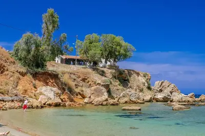 a person standing in the water on a beach at Park-view Lux Pool Villa, steps to the Beach in Aghii Apostoli