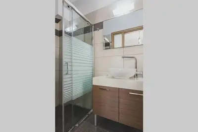 a bathroom with a sink and a shower at Park-view Lux Pool Villa, steps to the Beach in Aghii Apostoli