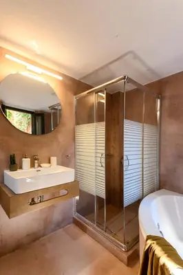 a bathroom with a shower and a sink and a mirror at Monastery apartment, a unique house in Chania Town