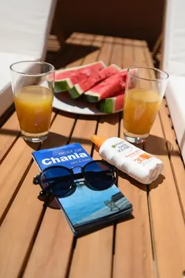 a table with sunglasses and a book and two glasses at Monastery apartment, a unique house in Chania Town