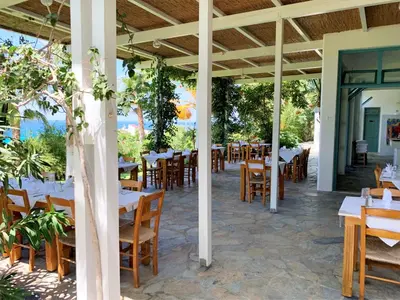 a restaurant with tables and chairs on a patio at Hotel Plakures in Falasarna