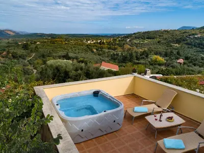 a hot tub on the balcony of a house at Villa Erontas -Private heated jacuzzi and mini pool in Makhairoí