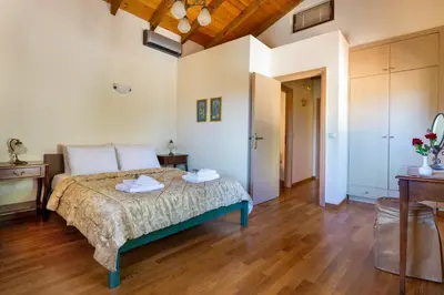 a bedroom with a bed and a wooden floor at Villa Erontas -Private heated jacuzzi and mini pool in Makhairoí