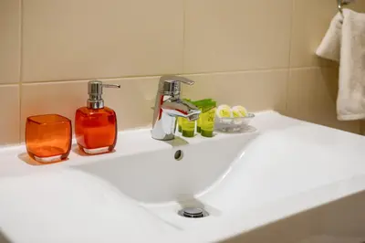 a bathroom sink with two soap bottles on it at Villa Erontas -Private heated jacuzzi and mini pool in Makhairoí