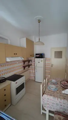 a kitchen with a table and a kitchen with a stove and refrigerator at Dominic Chania Center Apartment in Chania Town