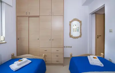 a bedroom with two beds and a dresser at Villa Thallo in Galatás
