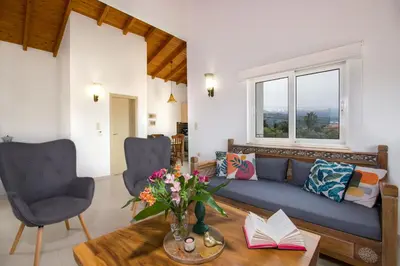 a living room with a blue couch and a table at Villa Thallo in Galatás