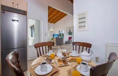 a kitchen and dining room with a table and a refrigerator at Villa Thallo in Galatás