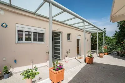 a house with potted plants on a patio at Olga's Organic garden Home for a couple! with Wifi & AC in Chania Town