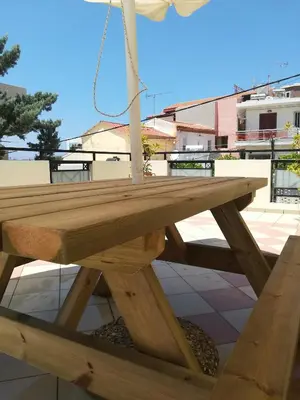 a wooden picnic table sitting on top of a patio at SHINE VERANDA PRIVE APTS 7PERSONS in Plataniás