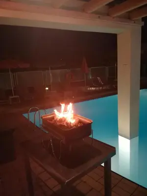 a fire sitting on a table next to a pool at SHINE VERANDA PRIVE APTS 7PERSONS in Plataniás