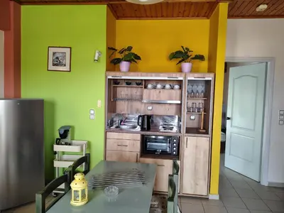 a kitchen with green and yellow walls and a table at SHINE VERANDA PRIVE APTS 7PERSONS in Plataniás