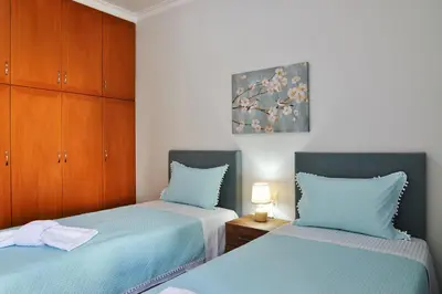 a bedroom with two beds with blue sheets at Aristea's Apartment 2nd Floor in Chania Town