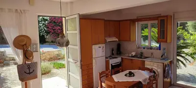 a kitchen with wooden cabinets and a table with a tableablish at Kalyves Mili's house sea view in Plaka