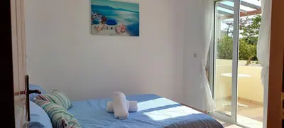a bedroom with a bed with a picture on the wall at Kalyves Mili's house sea view in Plaka