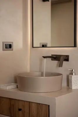 a bathroom with a white sink and a mirror at Chrissida Hotel in Agia Marina Nea Kydonias