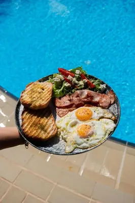 a plate of breakfast food with eggs sausage and toast at Chrissida Hotel in Agia Marina Nea Kydonias