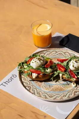 a plate of food with a salad and a glass of orange juice at Chrissida Hotel in Agia Marina Nea Kydonias