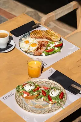 two plates of food on a table with eggs and a sandwich at Chrissida Hotel in Agia Marina Nea Kydonias