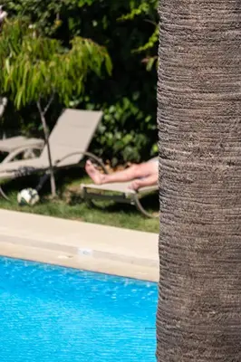 a person laying in a lawn chair next to a pool at Chrissida Hotel in Agia Marina Nea Kydonias