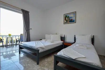 two beds in a room with a large window at KOYNTOYRA ROOMS in Kountoura Selino