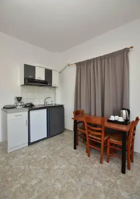 a kitchen and a table in a room at KOYNTOYRA ROOMS in Kountoura Selino