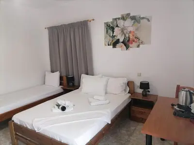 a hotel room with a bed and a desk and a table at KOYNTOYRA ROOMS in Kountoura Selino