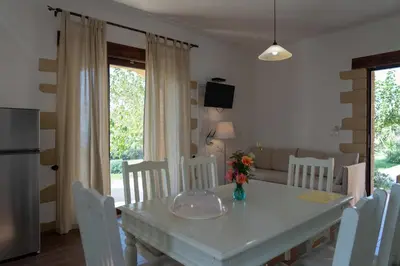 a kitchen and dining room with a white table and chairs at Sunset Villas in Falasarna