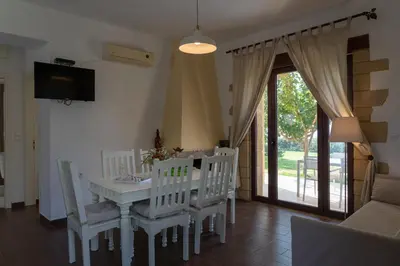 a dining room with a white table and chairs at Sunset Villas in Falasarna