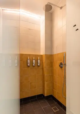 a shower stall with three soap bottles on the wall at Flâneur in Chania Town