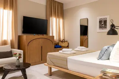 a hotel room with two beds and a television at Flâneur in Chania Town