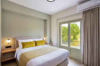 a bedroom with a bed and a large window at Dandelion apartments in Chania Town