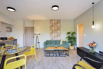 a living room with a blue couch and yellow chairs at Dandelion apartments in Chania Town