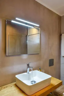 a bathroom with a white sink and a mirror at Dandelion apartments in Chania Town