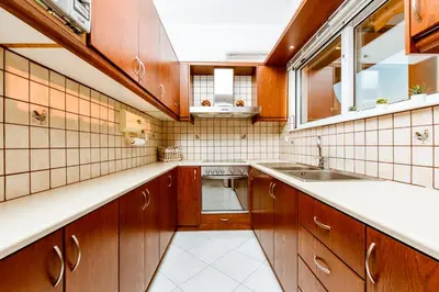 a kitchen with wooden cabinets and a sink at Chania Grand Nature Apartment in Chania Town