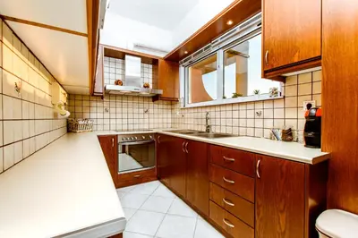 a kitchen with wooden cabinets and a sink and a window at Chania Grand Nature Apartment in Chania Town