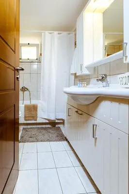 a white bathroom with a sink and a shower at Chania Grand Nature Apartment in Chania Town