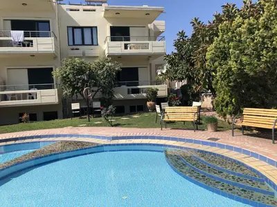 a swimming pool in front of a building at Lefka Apartments in Parigoría