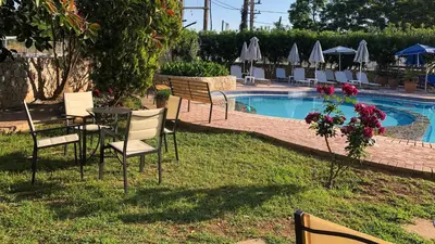a group of chairs and a table next to a pool at Lefka Apartments in Parigoría