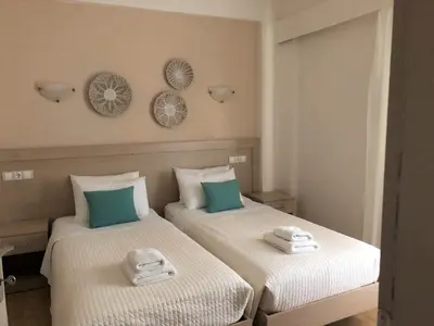 two beds in a room with towels on them at Lefka Apartments in Parigoría