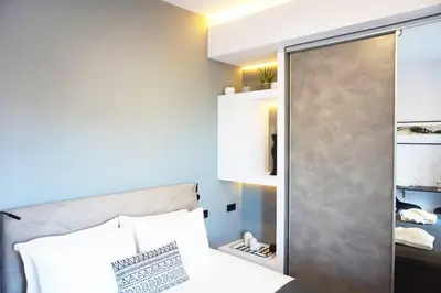 a small bedroom with a bed and a mirror at C-Home Studio in the heart of Chania in Chania Town