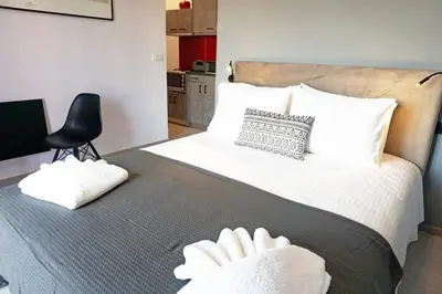 a bedroom with a large bed with two white towels on it at C-Home Studio in the heart of Chania in Chania Town