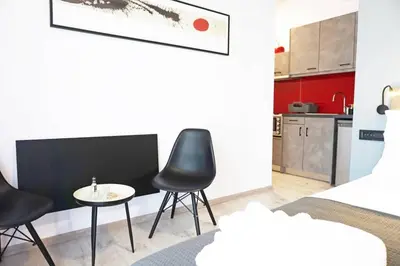 a room with two chairs and a table and a kitchen at C-Home Studio in the heart of Chania in Chania Town