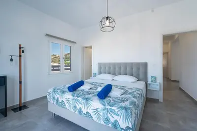 a bedroom with a large bed with blue pillows at Mira Sea View Residence in Chania Town
