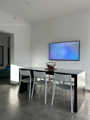 a dining room with a black table and white chairs at Mira Sea View Residence in Chania Town